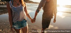 Couple holding hands at the beach during sunset 48jgX0