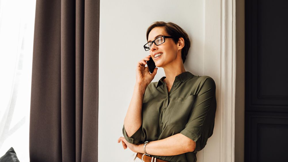 Woman leaning on wall taking a phone call