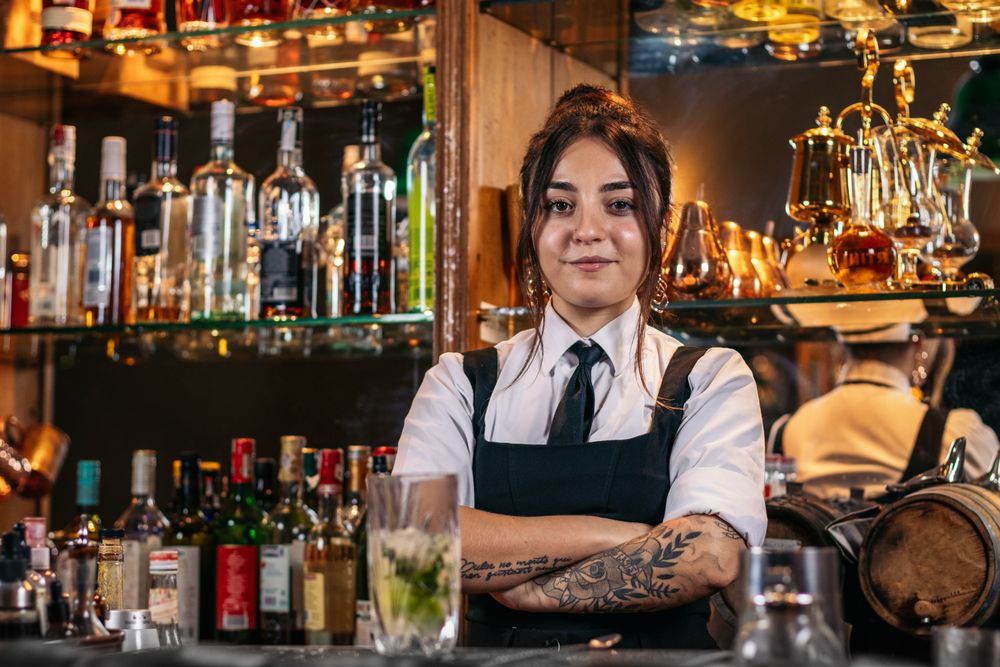 Portrait of a young female bartender in a traditional cocktail bar