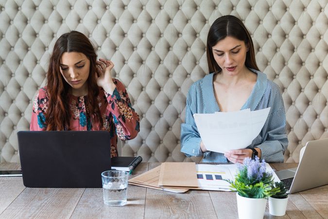 Focused women working on laptops in coworking space