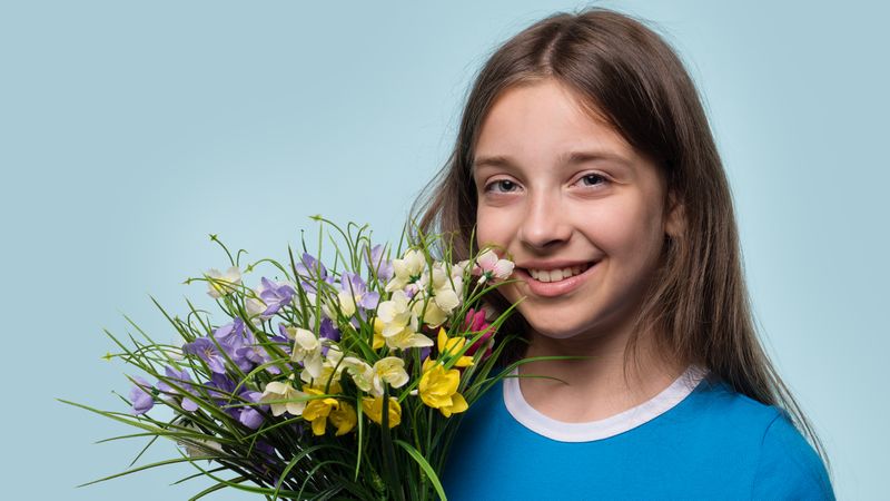 Girl smiling and holding colorful bouquet of flowers