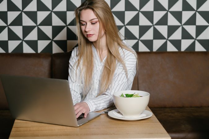 Young woman using laptop in cafe