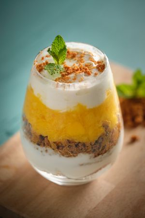 Delicious layered dessert in glass on table