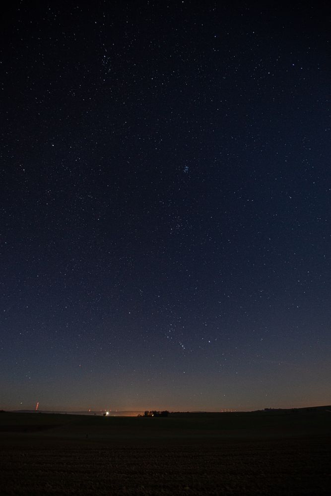 City lights in distance on dark starry night