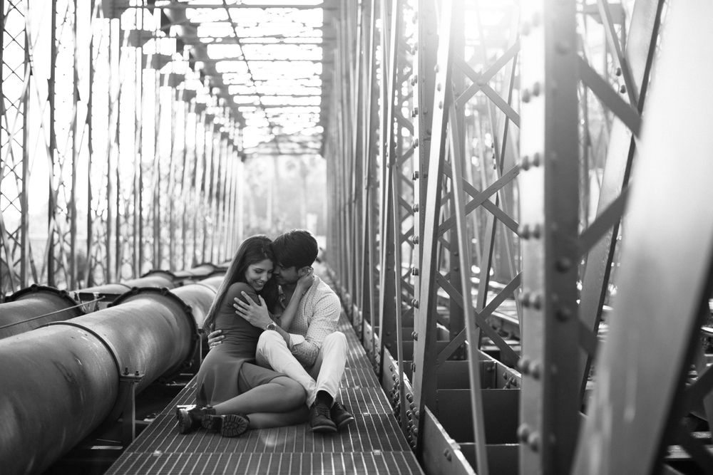 Amorous couple bonding on railway under bridge