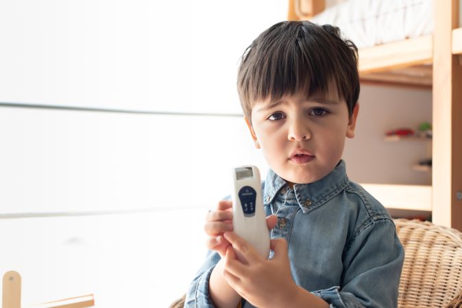 Boy holding digital thermometer