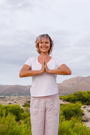 Barefoot woman meditating on stone
