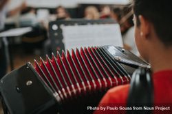 Rear view of student playing the accordion instrument 0WR8Ob