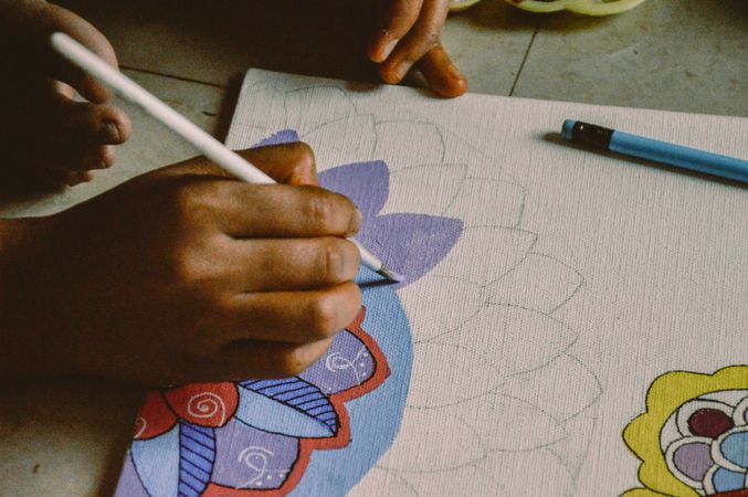 Cropped image of person drawing mandala on paper
