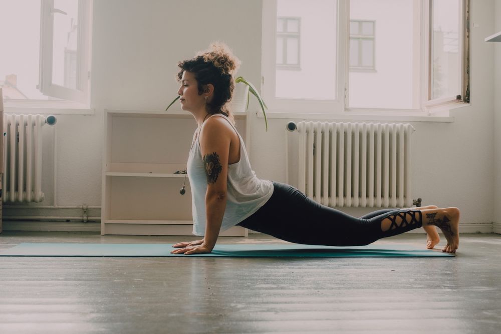 Calm woman practicing yoga pose and balancing on hands at home