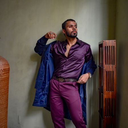 Man in purple outfit standing indoor