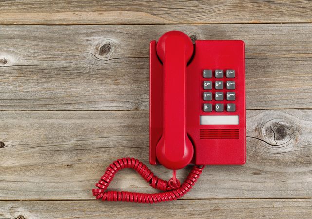 Vintage red phone on rustic wood