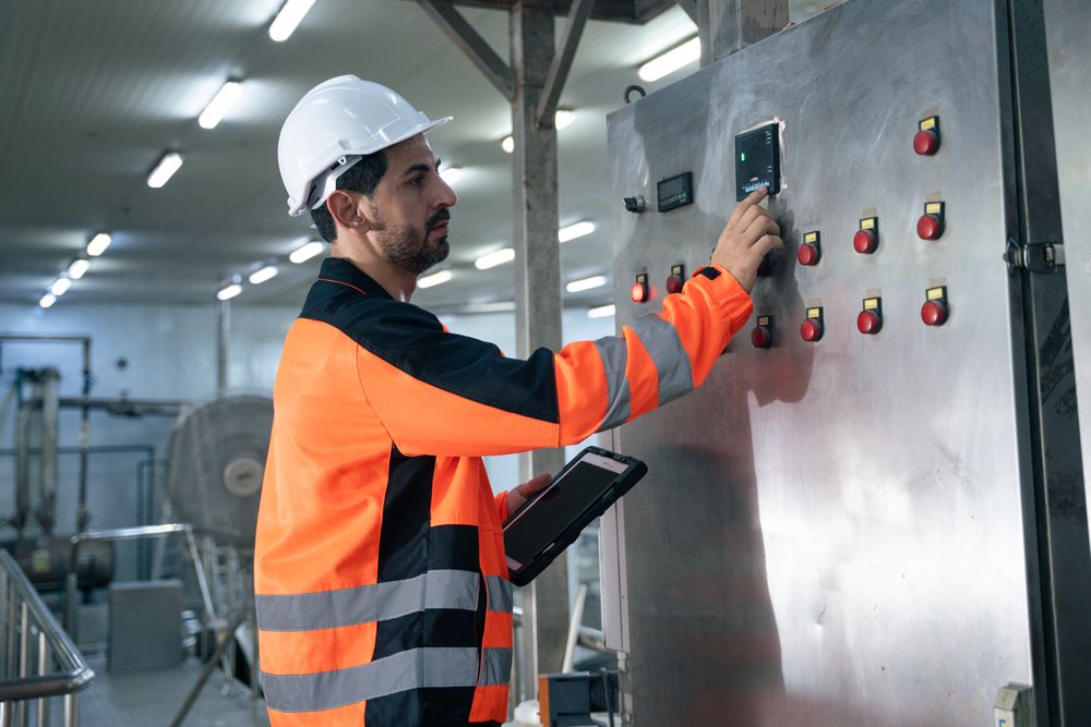 Engineer worker checking machine of conveyor belt system at the canned food factory.