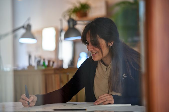 Positive woman working on project in workshop