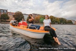 Outdoors shot of young friends relaxing on pedal boat on river in the city 4m67eb