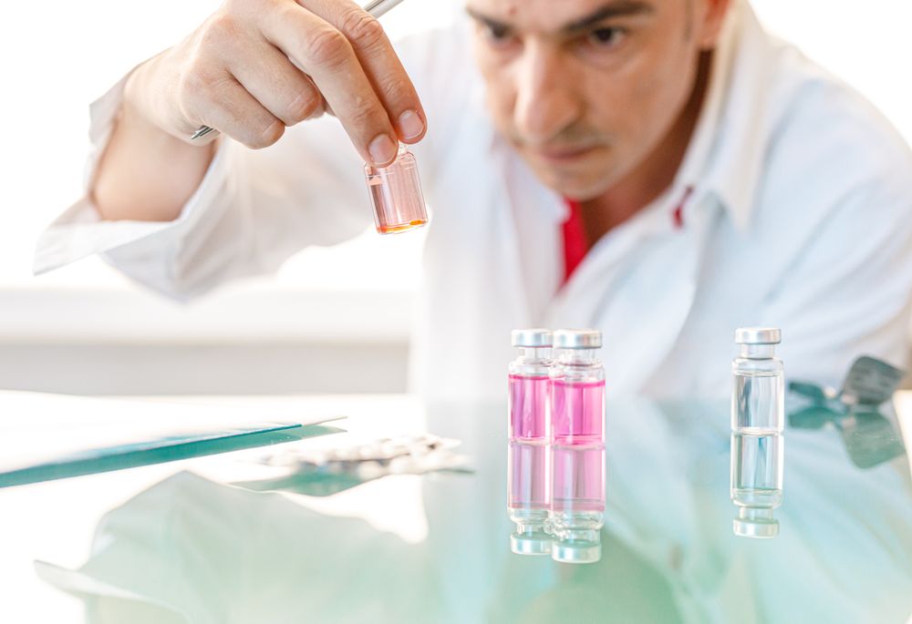 Man in white lab coat studying sample