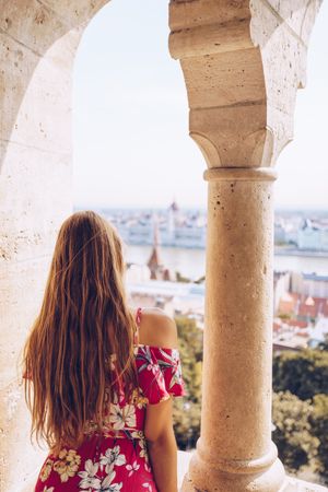 Woman sitting on columned marble fence
