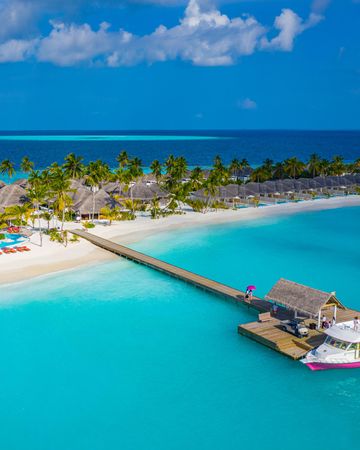 Beach holiday resort with long pier and boat