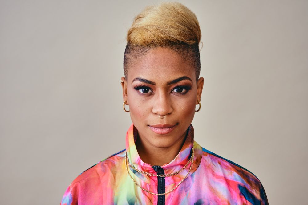 Studio shot of Black woman in bold 80s windbreaker jacket