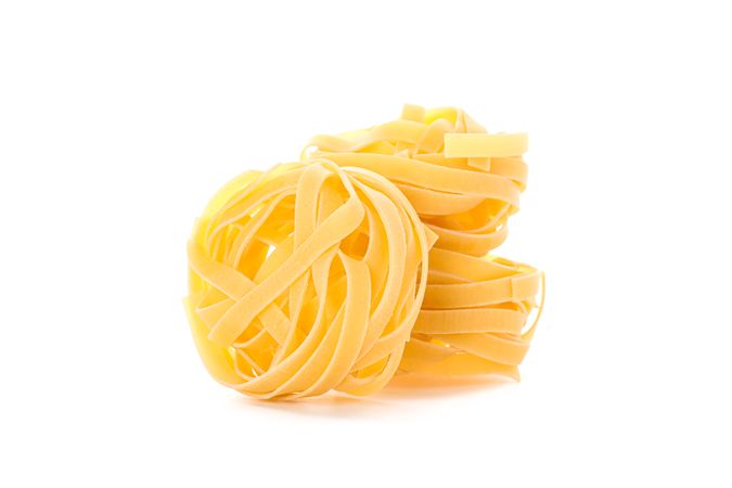 Pasta isolated on light background. Uncooked whole wheat pasta