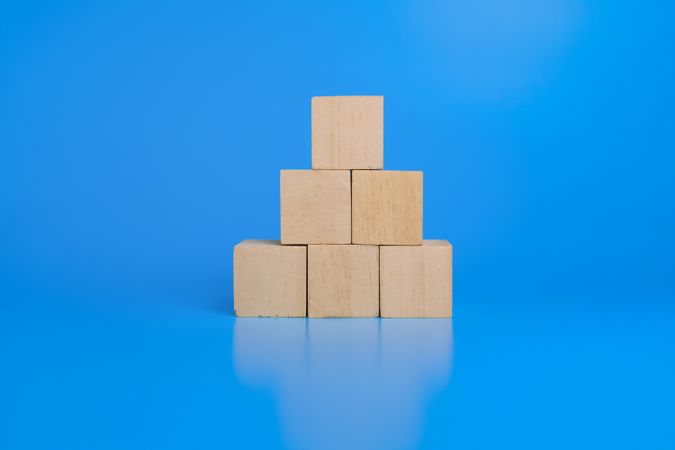 pyramid wooden blocks isolated on blue background