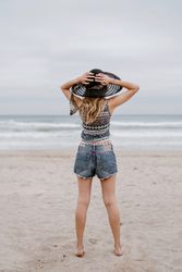 Young female relaxing on beach with hat