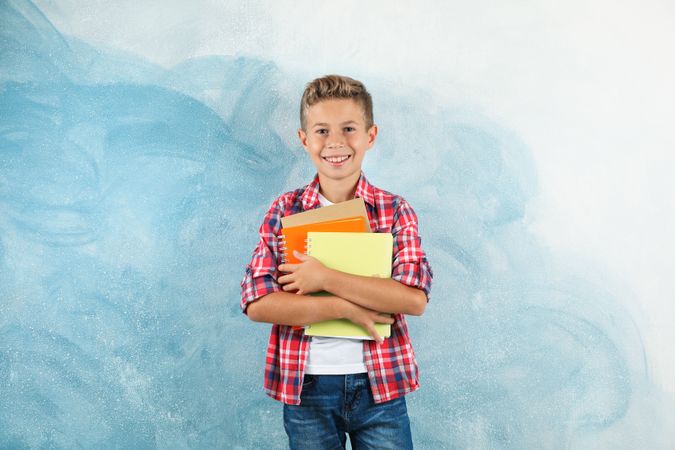 Boy with copybooks against color background, space for text