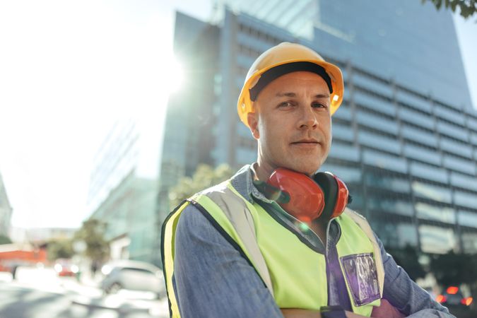 Confident workman looking at the camera while standing with his arms crossed in the city