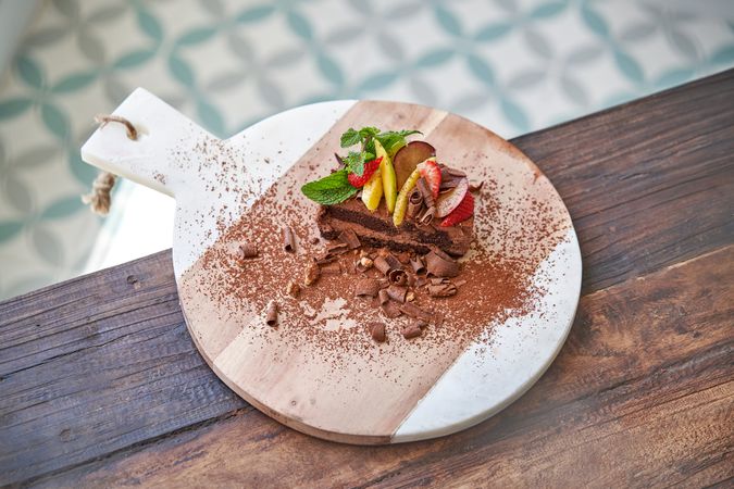 Delicious cake with mint leaves and fruits on wooden table