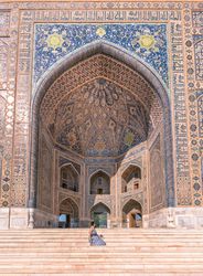 Woman sitting outside ancient building