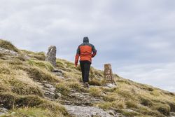 Man walking on hill near valley