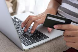 Female Hands Holding Credit Card and Using Laptop.