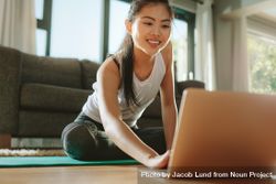 Woman using laptop while exercising at home 0g7dW0