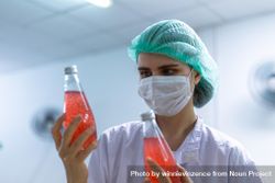 Woman checking drink bottles in factory 4BOveb
