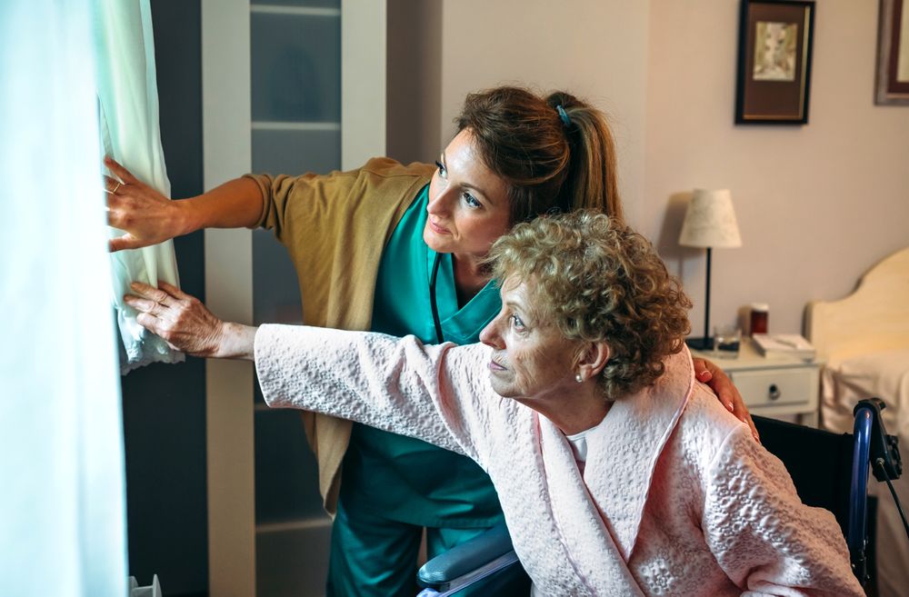 Caregiver showing the view through the window to mature patient