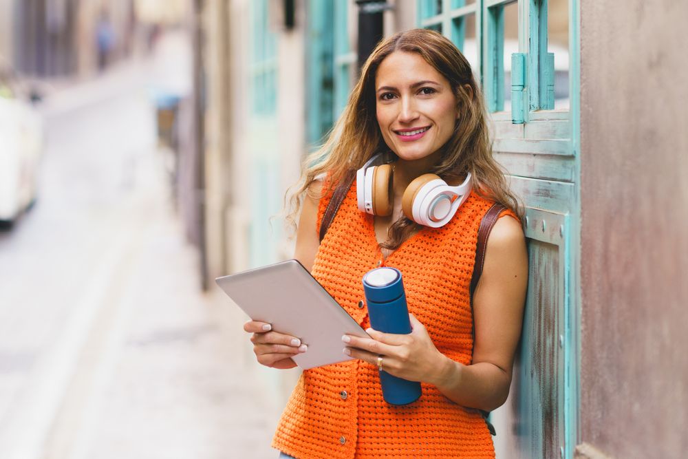 Woman standing on street with tablet