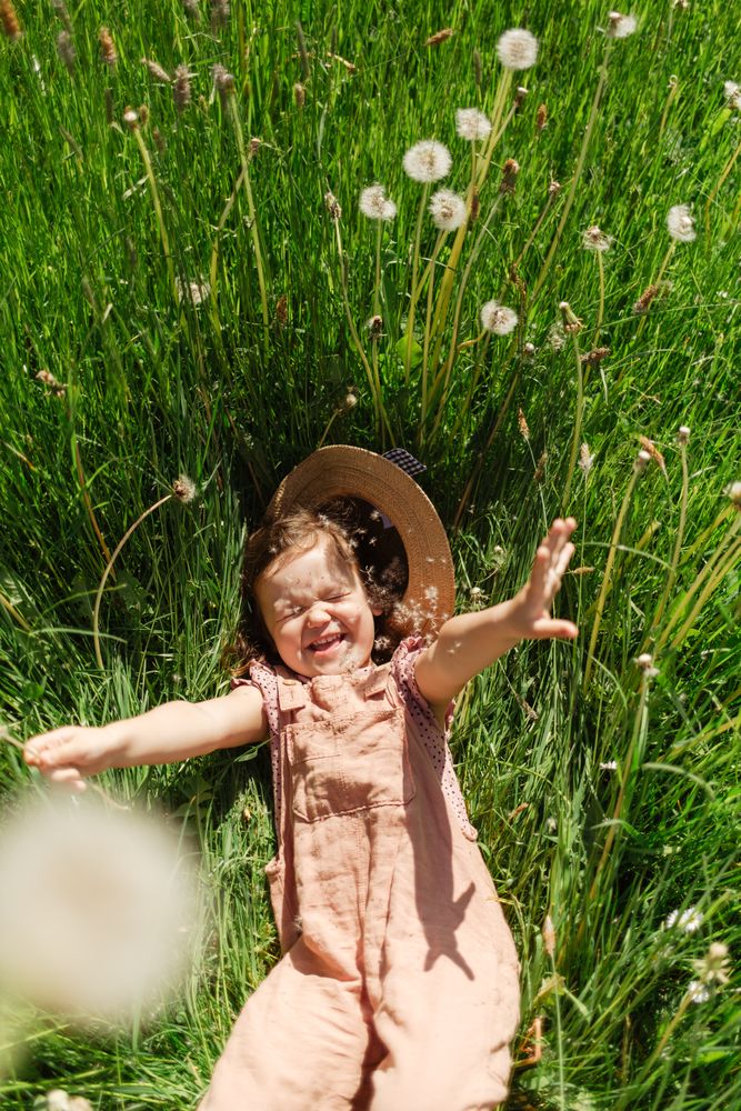Happy little girl lying on grass