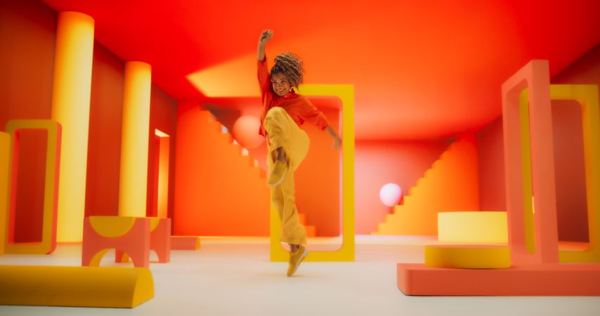 Black Woman in Bright Outfit Dancing Energetically in Geometric Abstract Orange, Yellow Environment.