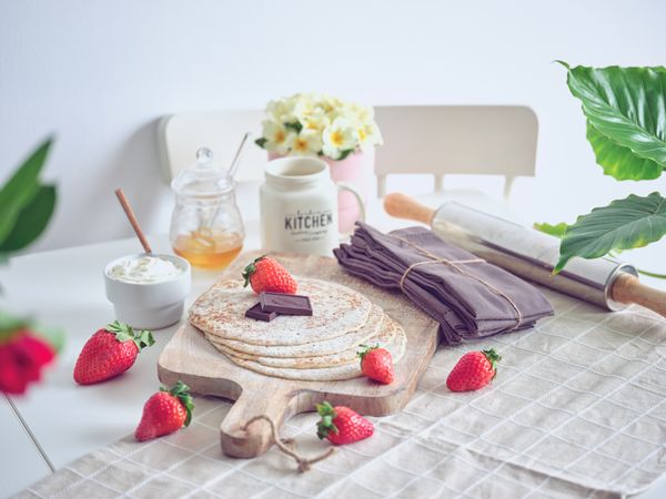 Delicious pancakes with berries and chocolate on table