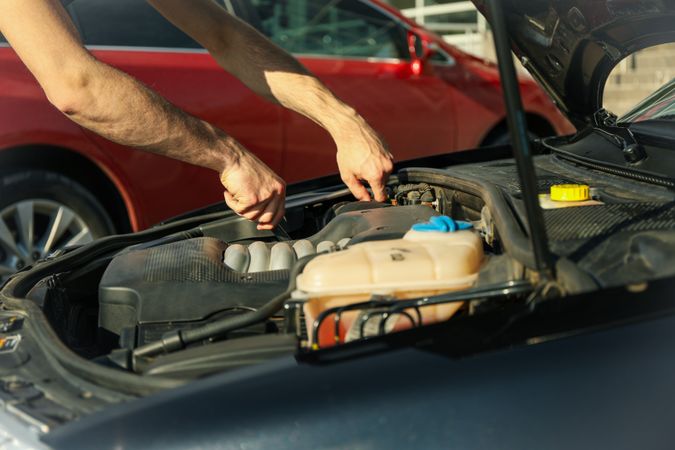Man fixing engine. Car inspection. Work of mechanic