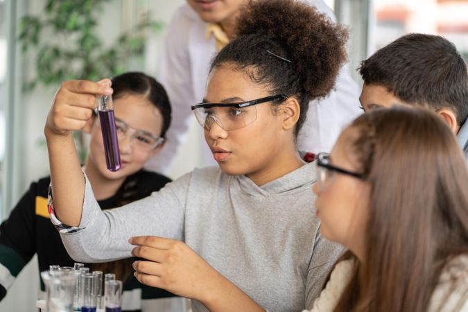Multi-ethnic students in science class doing chemical experiment with test tube