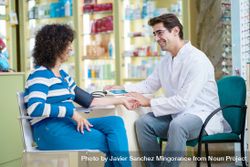 Cheerful pharmacist and woman customer in pharmacy 4OdrzE