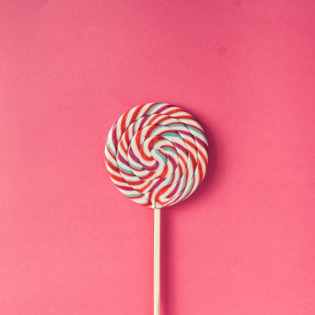 Swirling lollipop against pink background