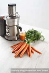 Display of bunch of carrots and professional juicing equipment 5roa74