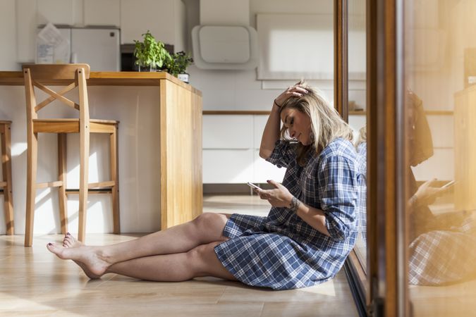 Woman at home leaning in a windows