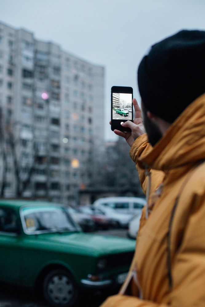 Man taking photo of vehicle on an overcast day
