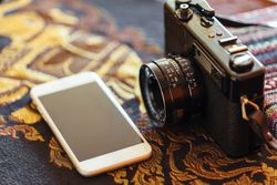 Phone next to a vintage camera