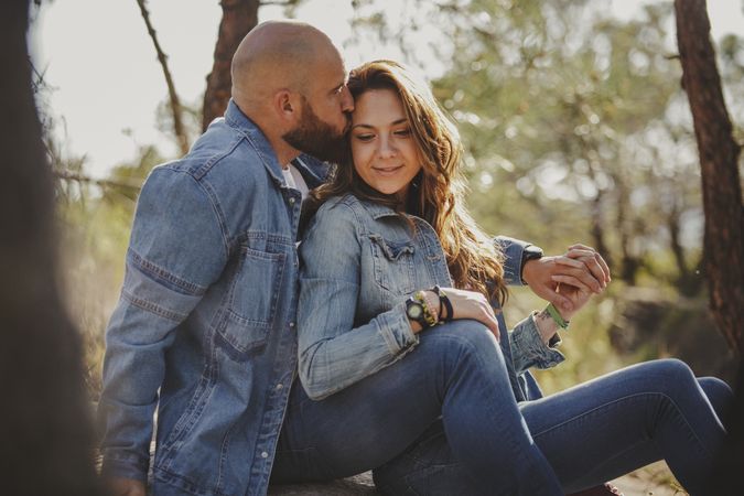 Sensual couple embracing while sitting at mountain valley
