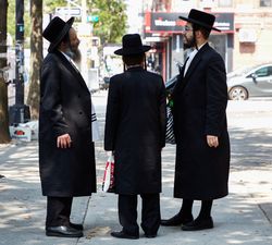 Three Hasidic Jews in a traditional long, dark jackets and hats, Brooklyn, New York v4m9z4