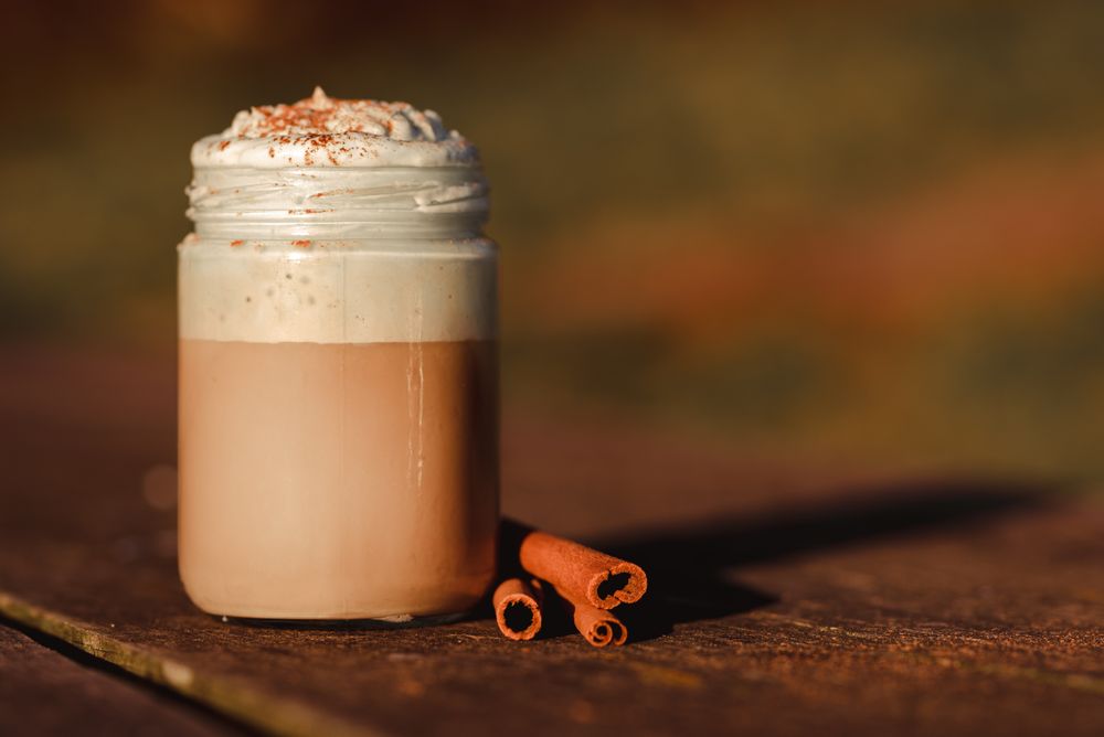 Cinnamon near coffee on table